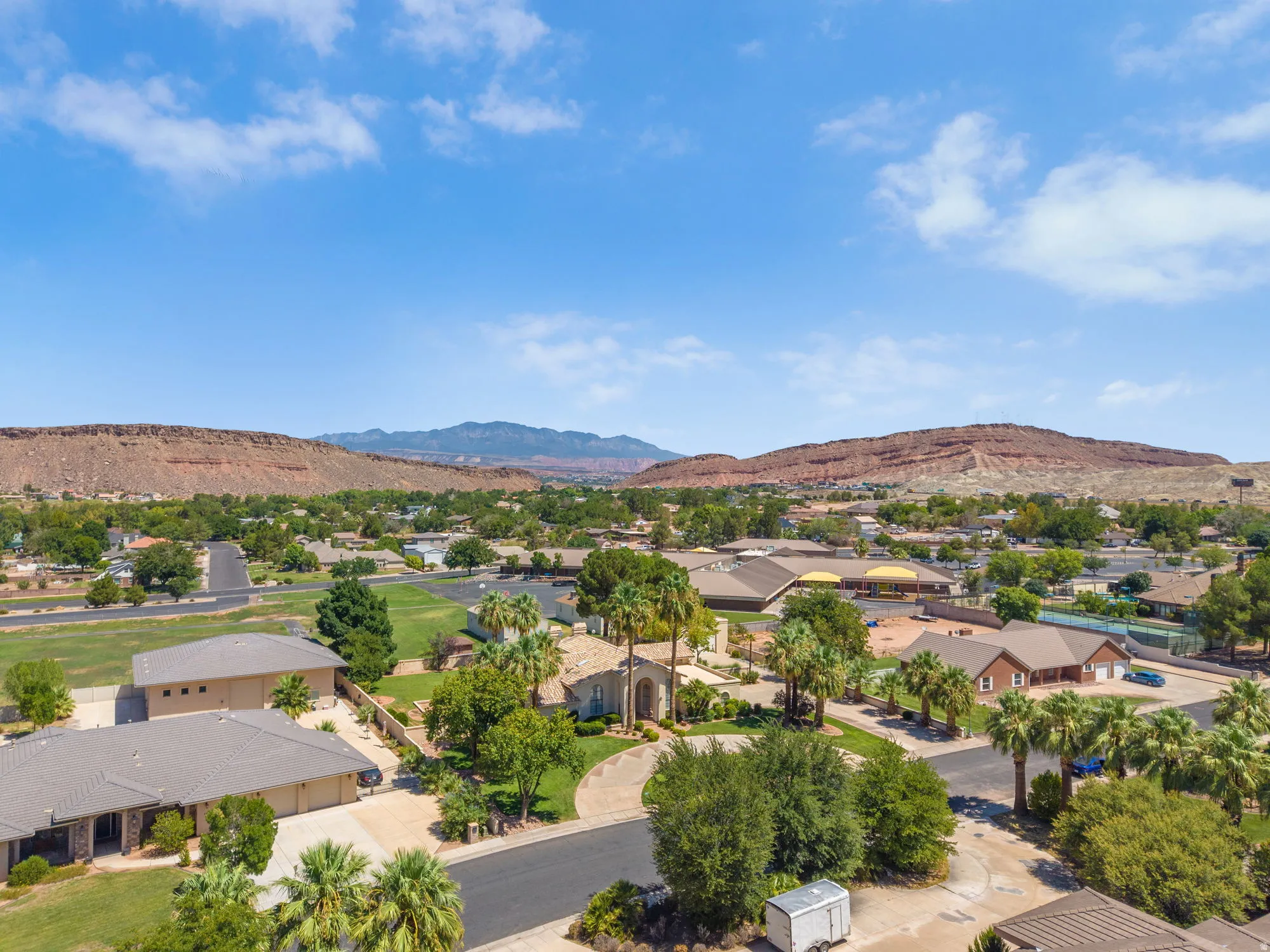 Aerial view showcasing a sprawling residential community nestled against dramatic desert mountain backdrop