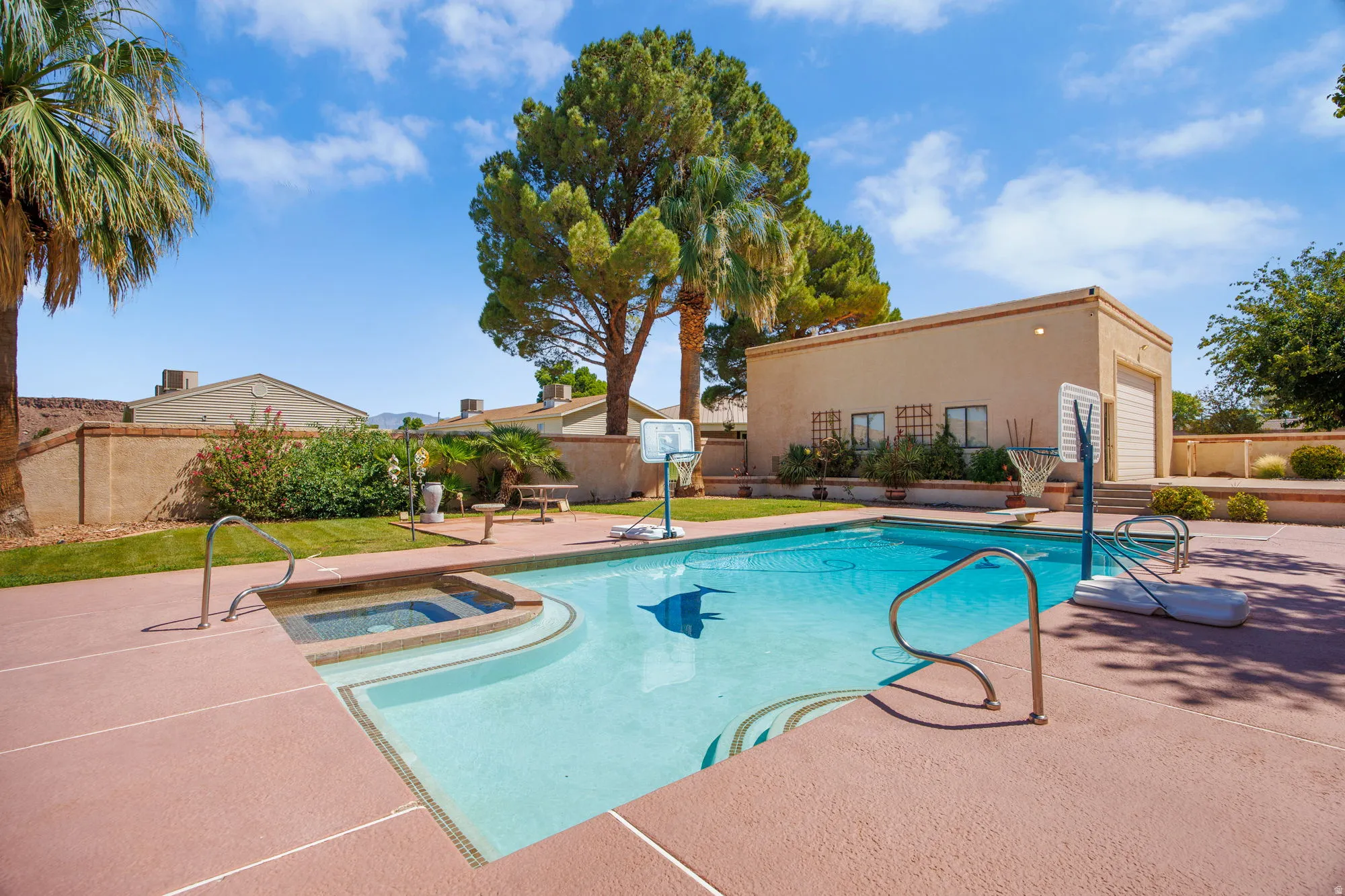 Outdoor swimming pool with integrated spa and surrounding hardscaping