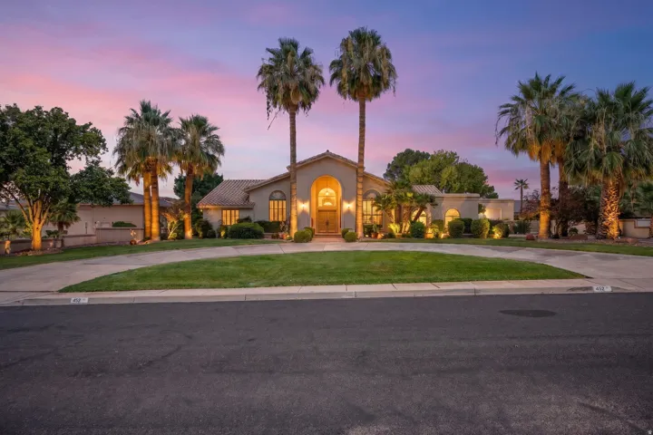 Elegant single-story residence showcasing a curved architectural entry with arched detailing and warm ambient lighting