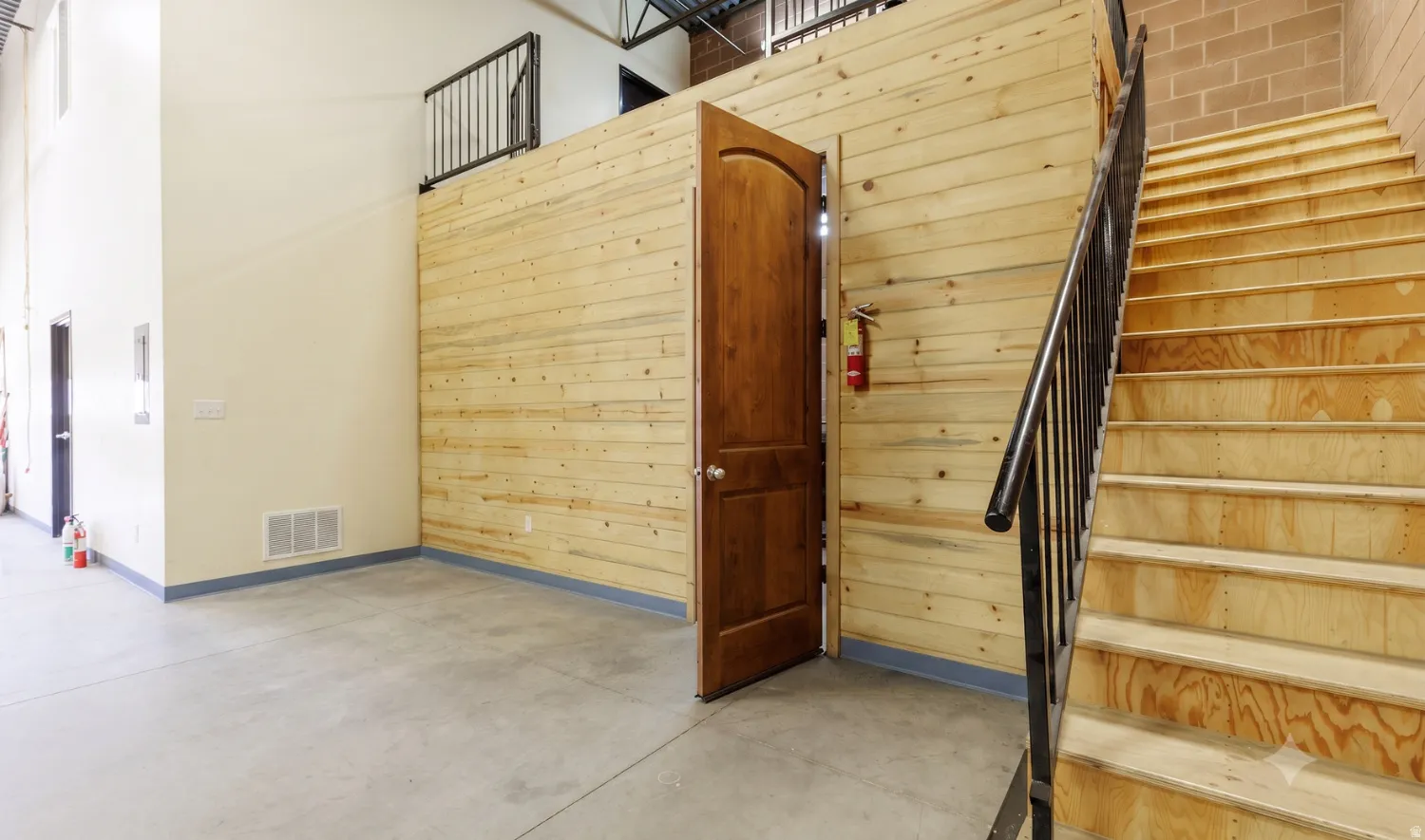Stairs to upper office; storage beneath mezzanine