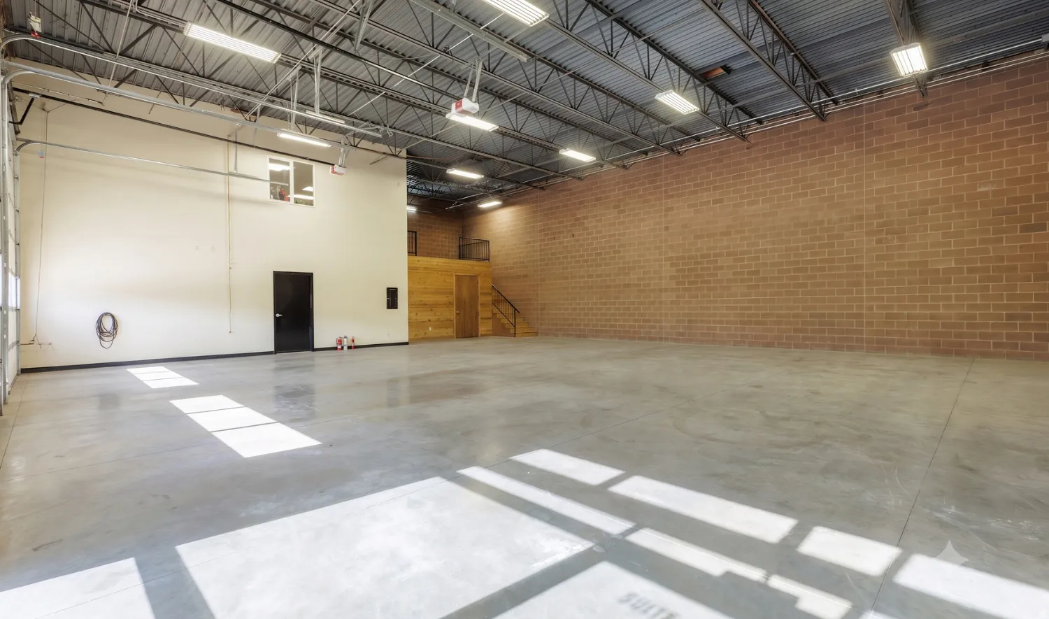 Warehouse — high-output lighting, exposed steel truss ceiling