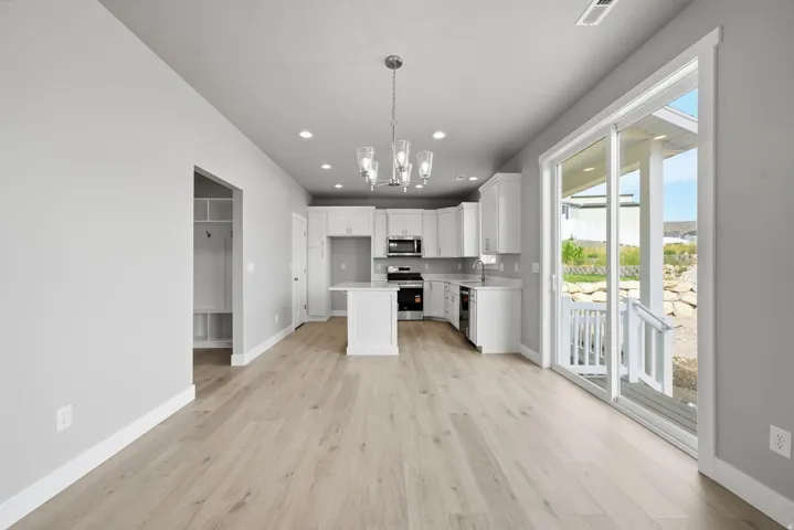 Open-concept living area with wood-finish flooring, recessed lighting, and a modern chandelier
