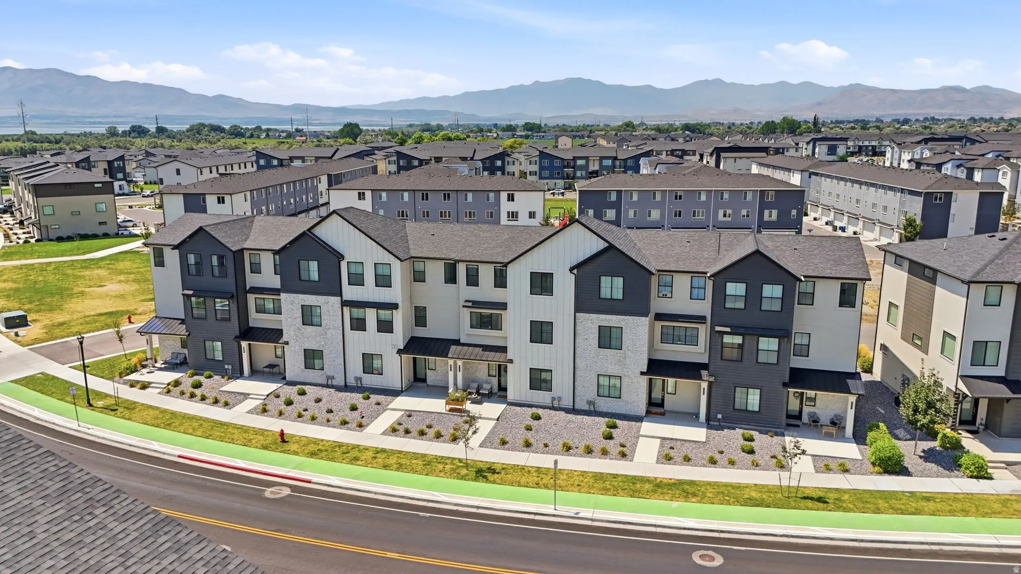 Modern townhome exteriors featuring varied siding, dark-framed windows, and covered entryways