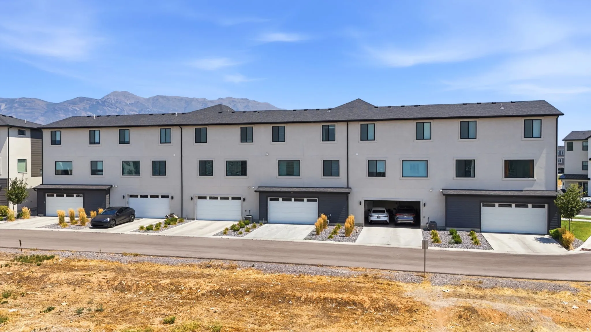 Modern townhome exterior with light-colored siding and dark trim