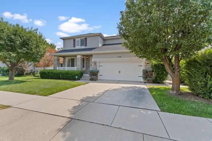 Two-story exterior with stone accents, a covered front porch, and an attached two-car garage