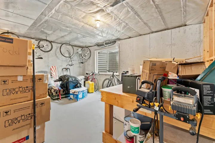 Unfinished basement space with concrete walls, exposed ceiling insulation, and a utility window