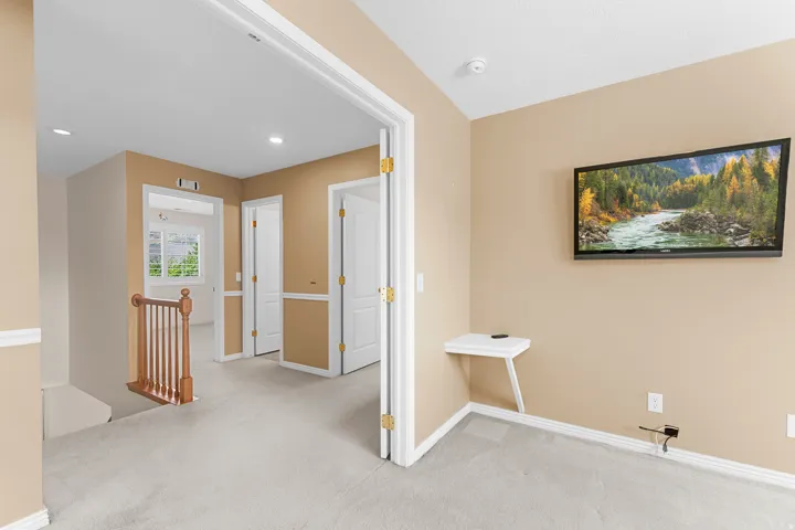 Upper-level landing featuring light-colored carpeting and recessed lighting