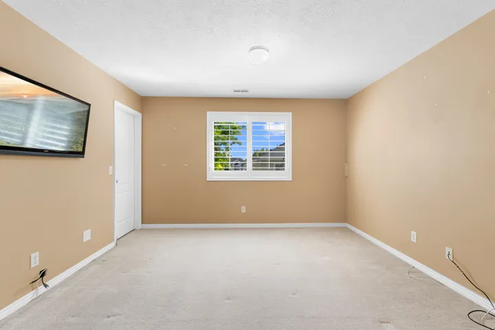 Single window with white shutters, carpeted flooring, and a flush-mount ceiling light