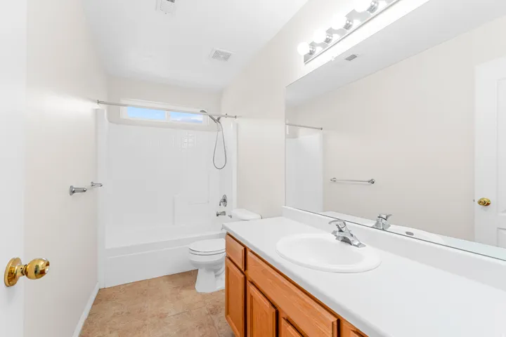 Bathroom featuring a single vanity, integrated sink, and wood-finish cabinetry