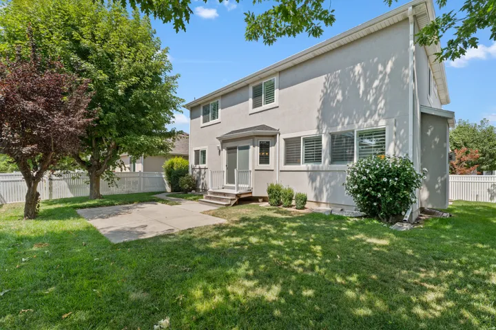 Private fenced yard featuring a concrete patio and mature trees