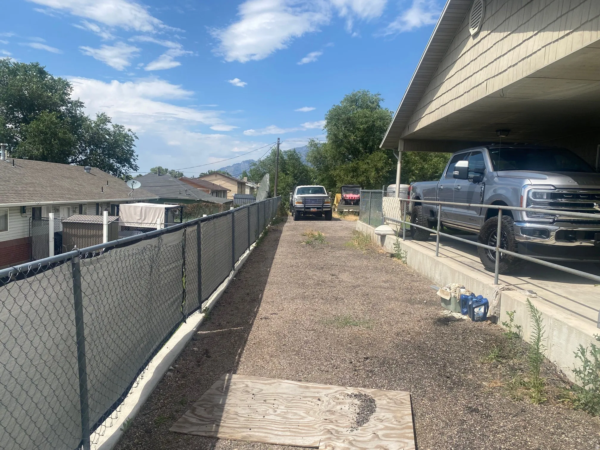 Covered carport structure with shingle-style siding