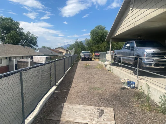 Covered carport structure with shingle-style siding
