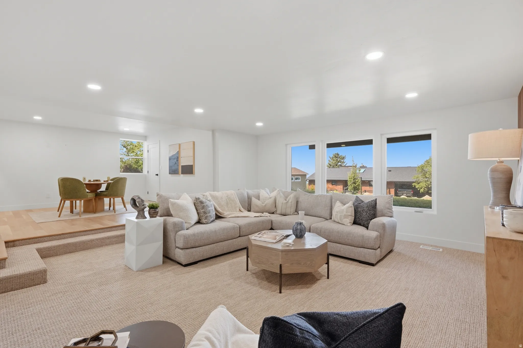Recessed lighting, wood-finish flooring, and a dining area with a built-in step