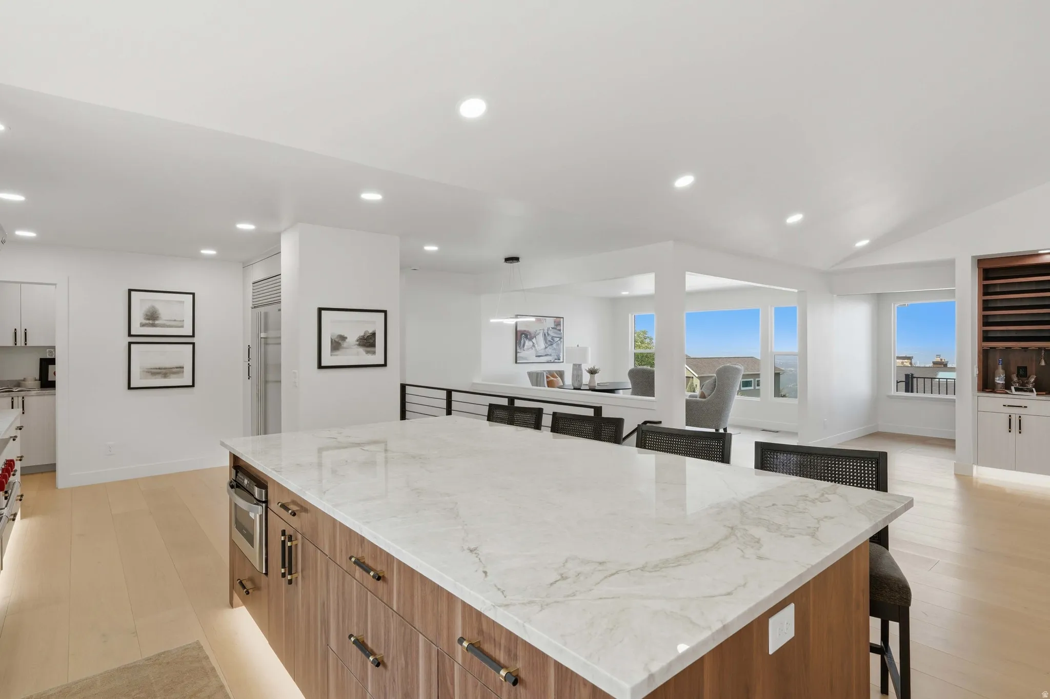 Expansive kitchen island with a stone-finish countertop, integrated microwave, and under-cabinet lighting