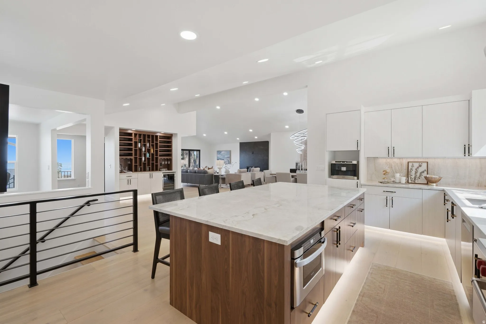 Contemporary kitchen featuring a large island with stone countertop, integrated oven, and wood-finish cabinetry