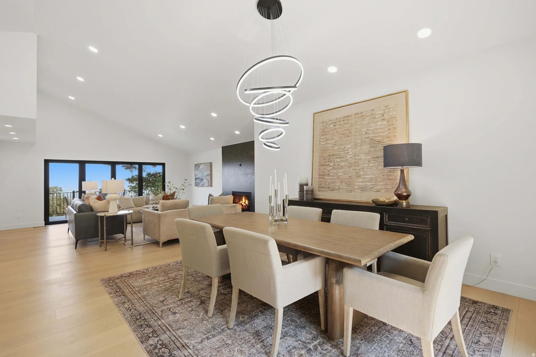 Vaulted ceilings, recessed lighting, expansive glass doors, wood-finish flooring, and a built-in fireplace