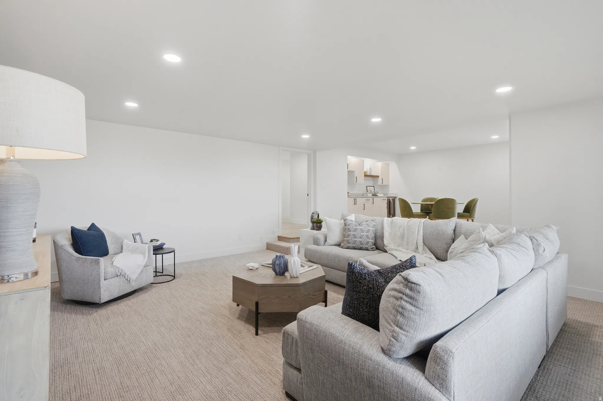 Recessed ceiling lighting, light-toned wall finishes, and integrated carpet flooring