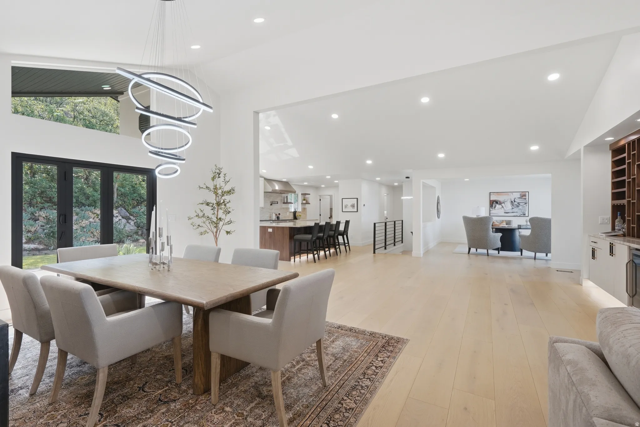 Spacious dining area featuring wood-finish flooring, a contemporary chandelier, and French doors