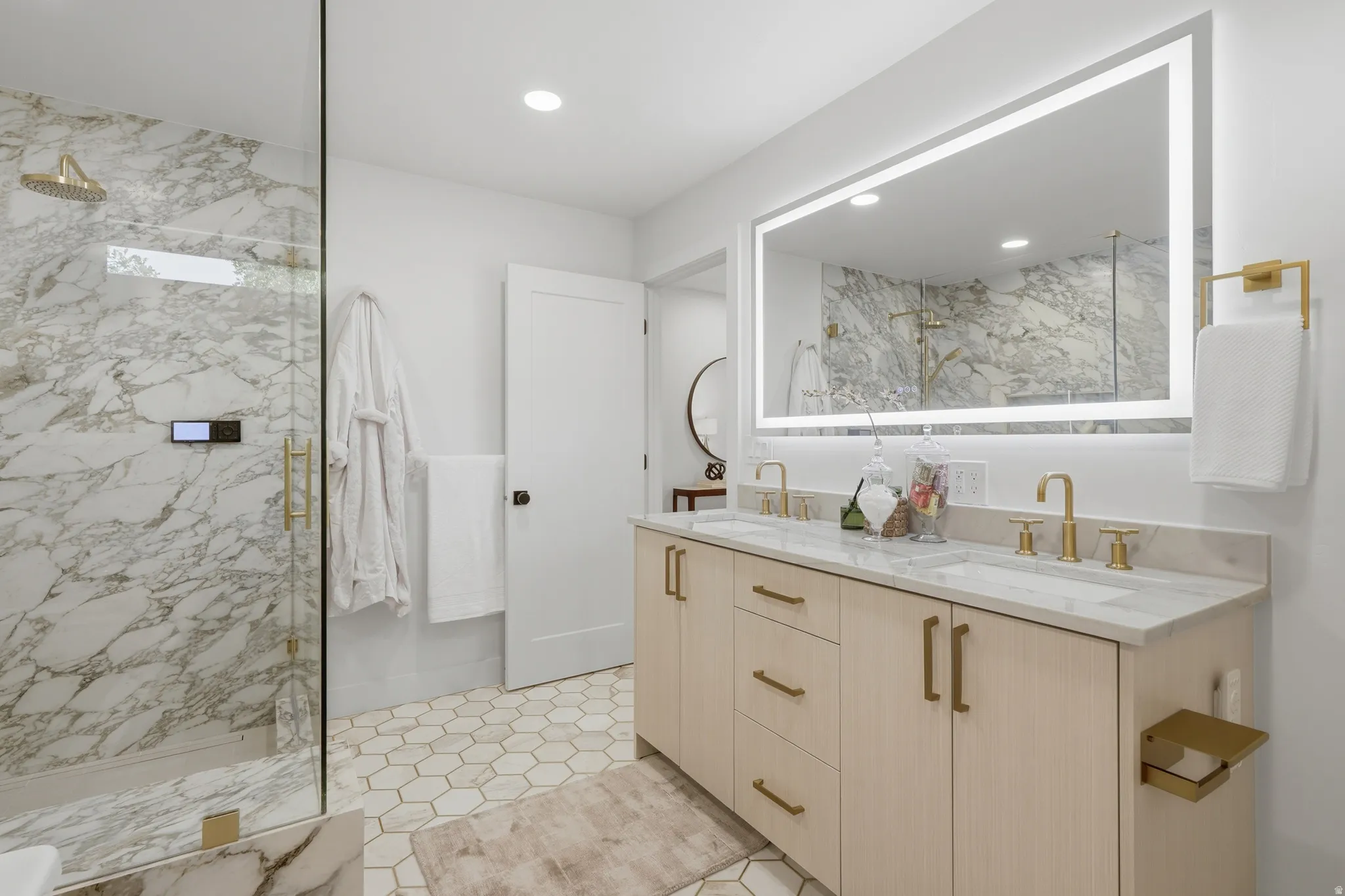 Walk-in shower with full height stone-finish tiling and glass enclosure