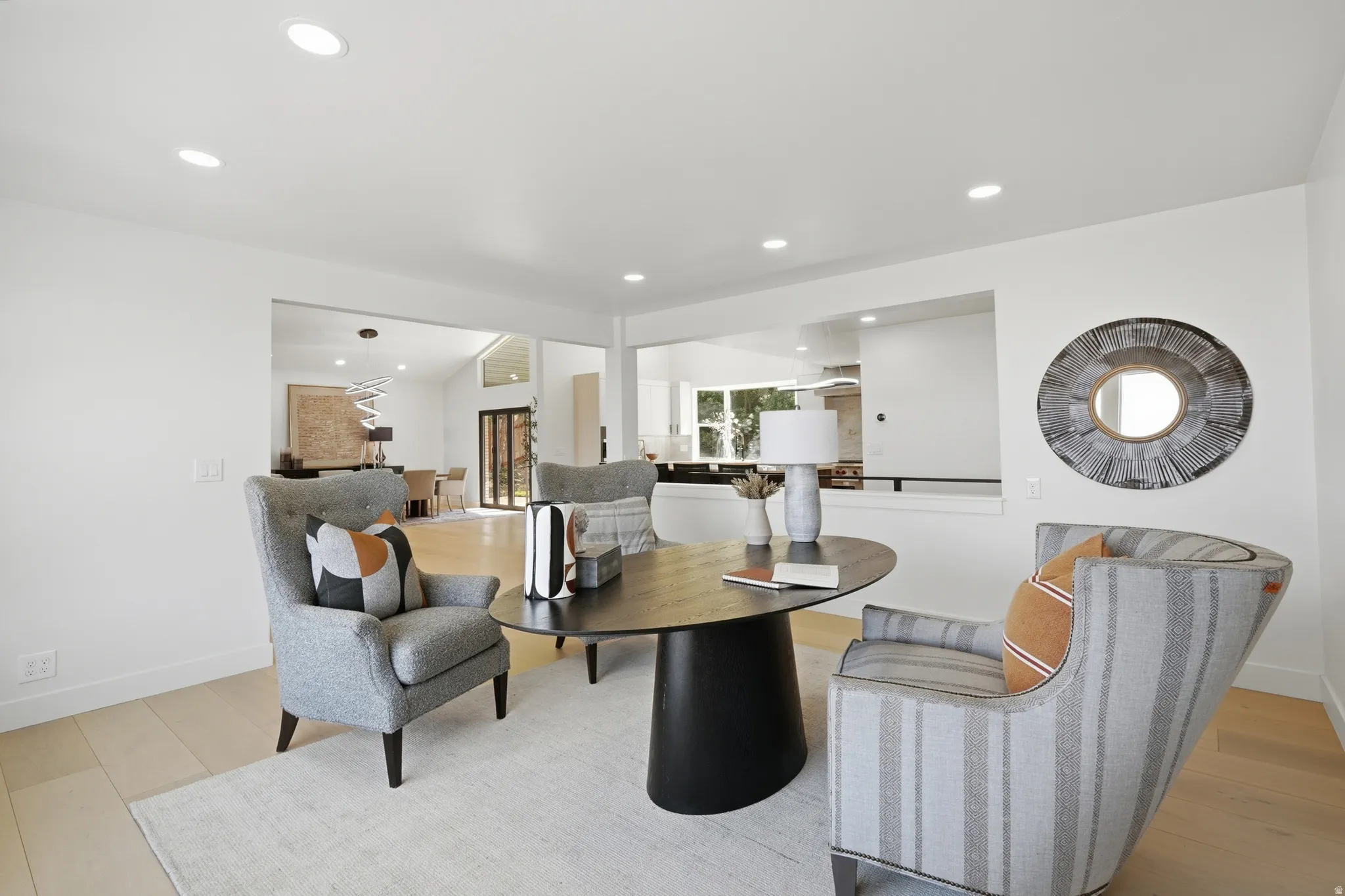 Recessed ceiling lighting, light wood-finish flooring, and white wall finishes