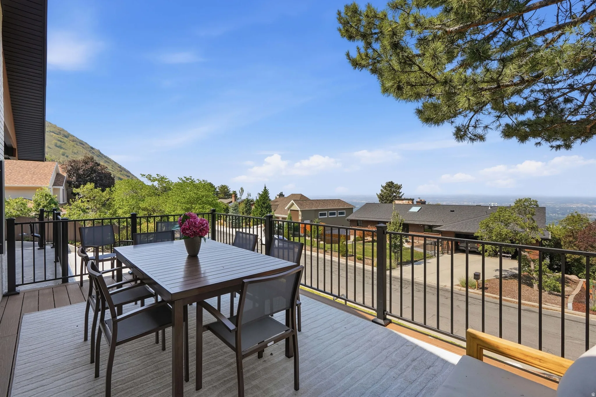 Spacious outdoor deck with composite decking, black metal railings, and mountain scenery