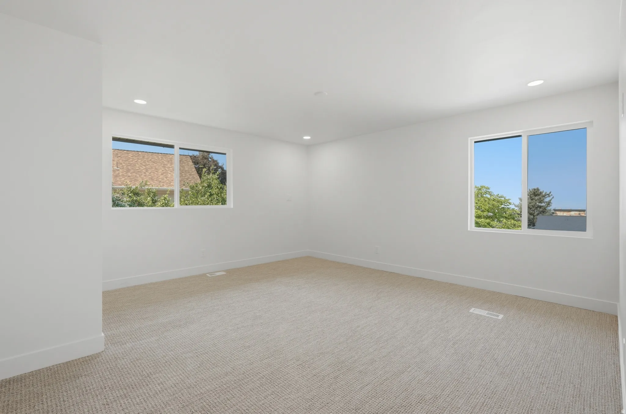 Neutral wall color, recessed lighting, and two windows