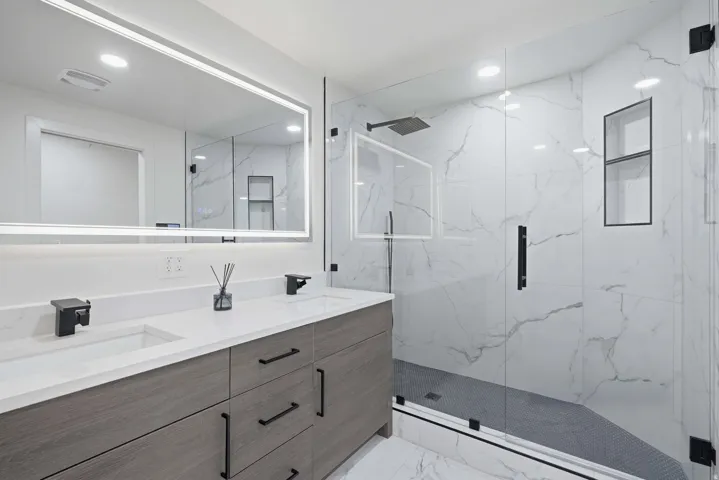 Dual vanity with integrated sinks, quartz countertop, and wood-finish cabinetry