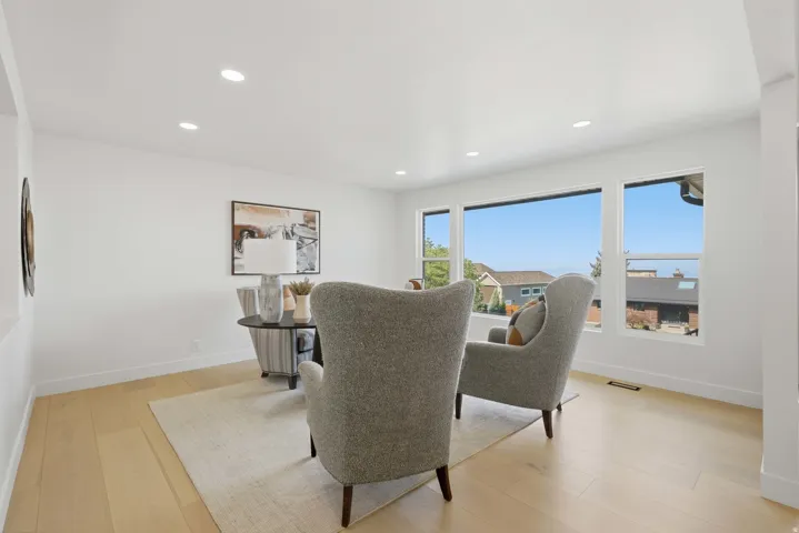 Expansive windows with surrounding scenery, wood-finish flooring, recessed lighting, and crisp white walls