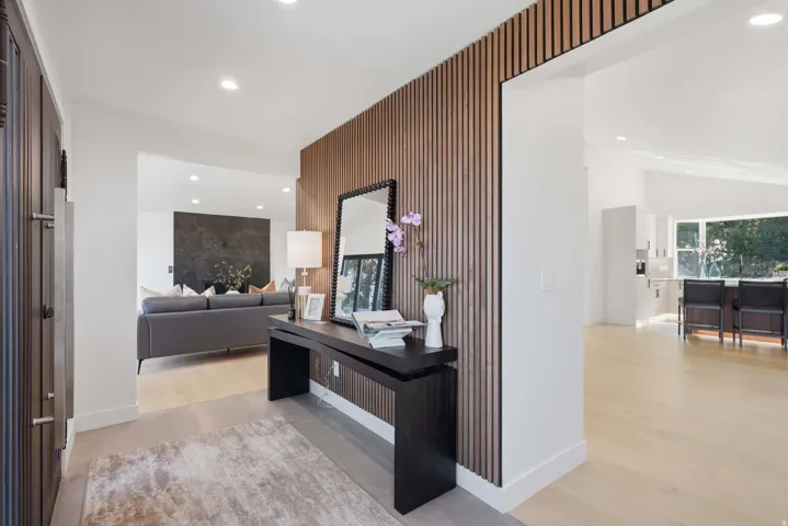 Entryway featuring a wood-slat accent wall, recessed lighting, and light wood-finish flooring