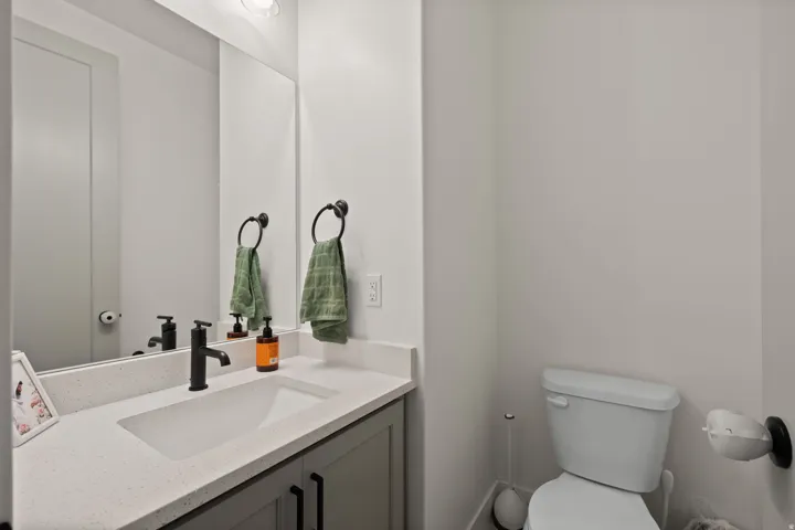 Vanity with an integrated sink, black matte faucet, light-colored countertop, and gray cabinetry