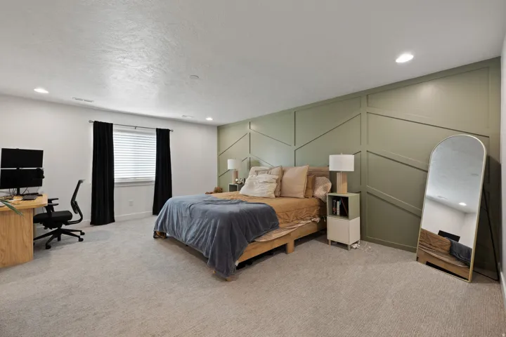Textured accent wall, recessed lighting, wall-to-wall carpeting, window with blinds, and built-in closet