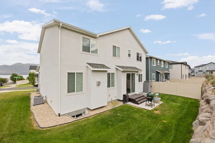 Backyard featuring a privacy fence, a concrete patio, and a grass lawn