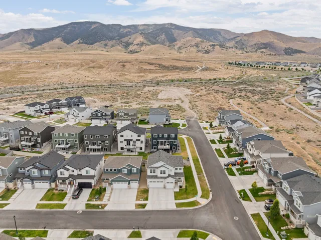 New construction community with varied architectural styles, asphalt streets, concrete driveways, and manicured lawns
