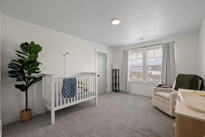 Spacious room with light gray carpet, white walls, and a prominent window