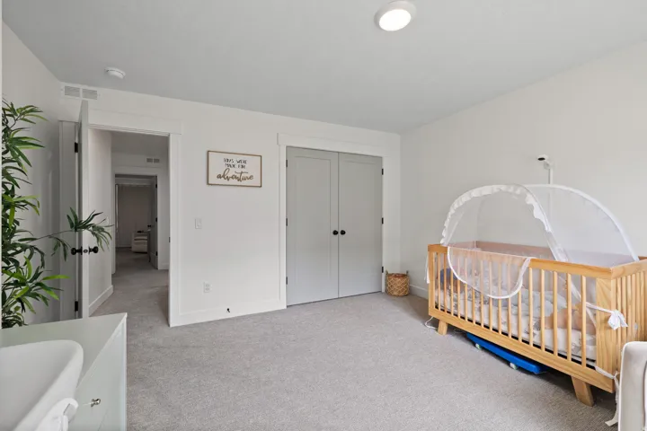 Neutral wall paint, light gray carpeting, recessed ceiling lighting, and gray paneled closet doors with black hardware
