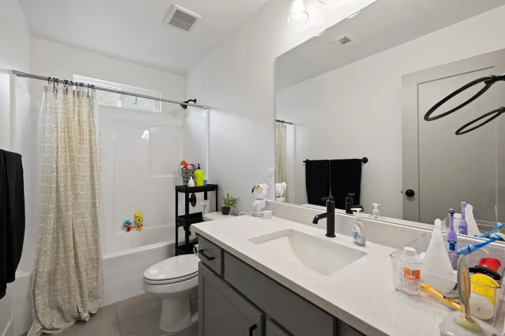 White vanity with an integrated rectangular sink, light-toned countertop, and matte black faucet