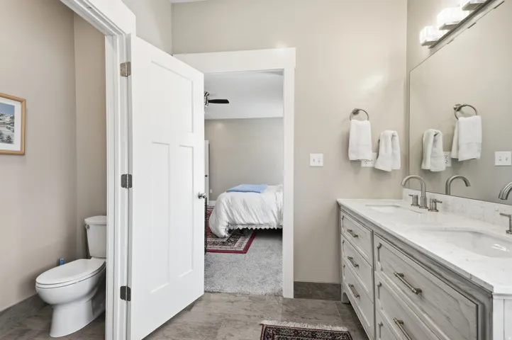 Double vanity with undermount sinks, stone countertop, and brushed nickel fixtures
