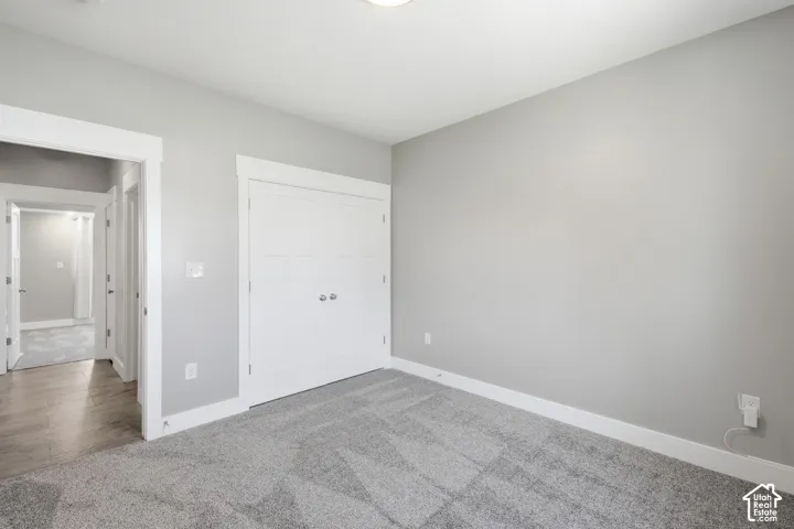 Recessed lighting, light gray wall finish, carpet flooring, base molding, and a built-in closet with double doors