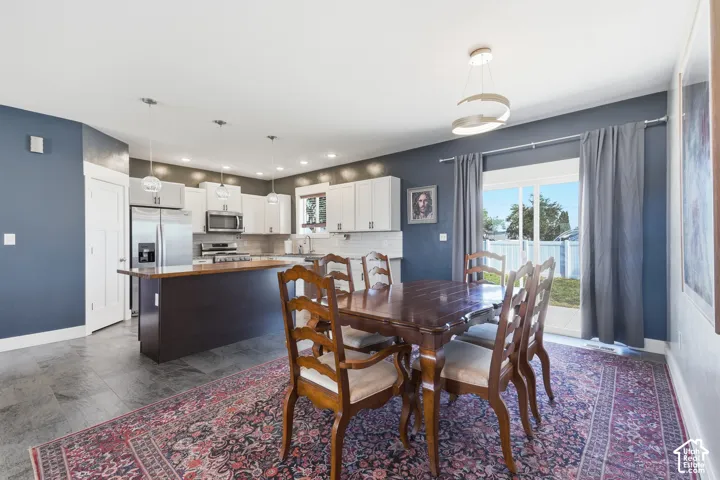 Kitchen with white cabinetry, stainless steel appliances, and a wood-finish island countertop