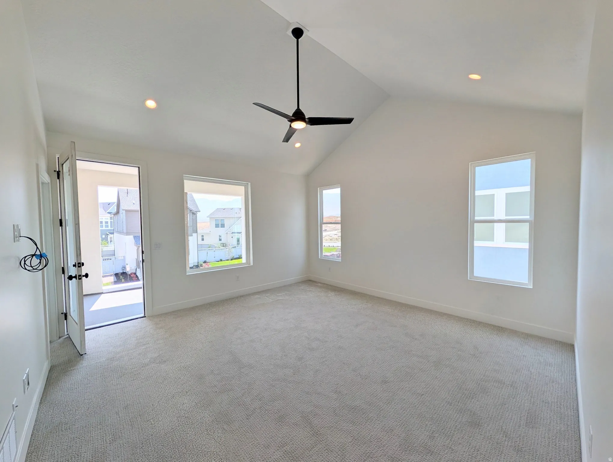 Primary bedroom with Vaulted ceiling with recessed lighting and a ceiling fan with access to balcony