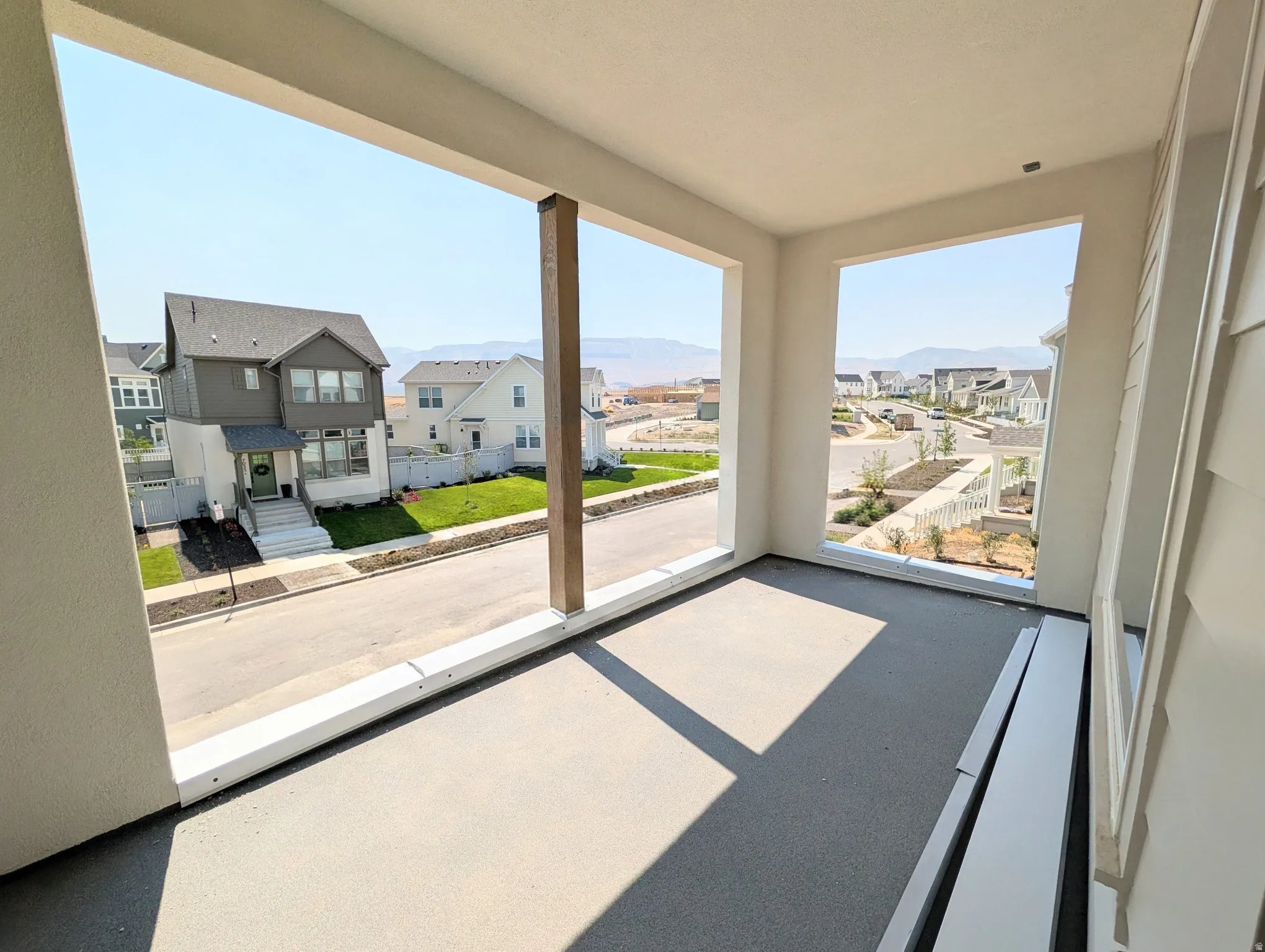 Covered balcony framed by white exterior walls and a vertical wood-finish structural beam
