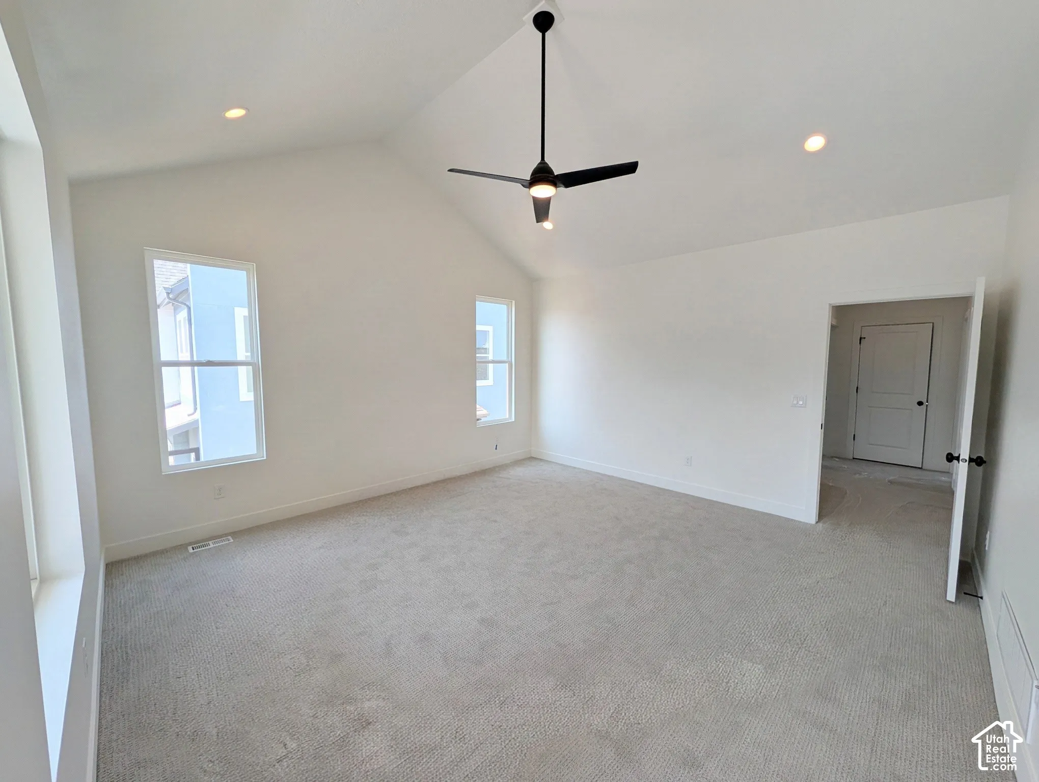 Primary bedroom with Vaulted ceiling with a black ceiling fan, recessed lighting, and carpet flooring