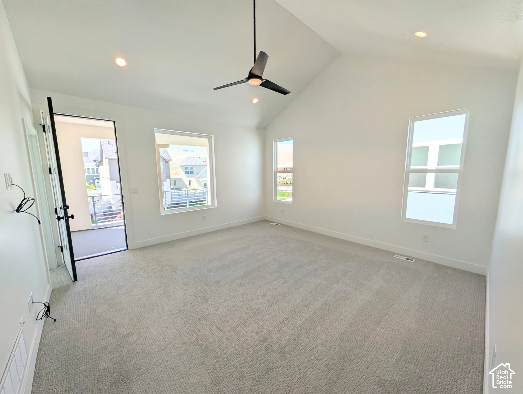 Primary bedroom with Vaulted ceiling with a ceiling fan, recessed lighting, light gray carpet, and multiple windows