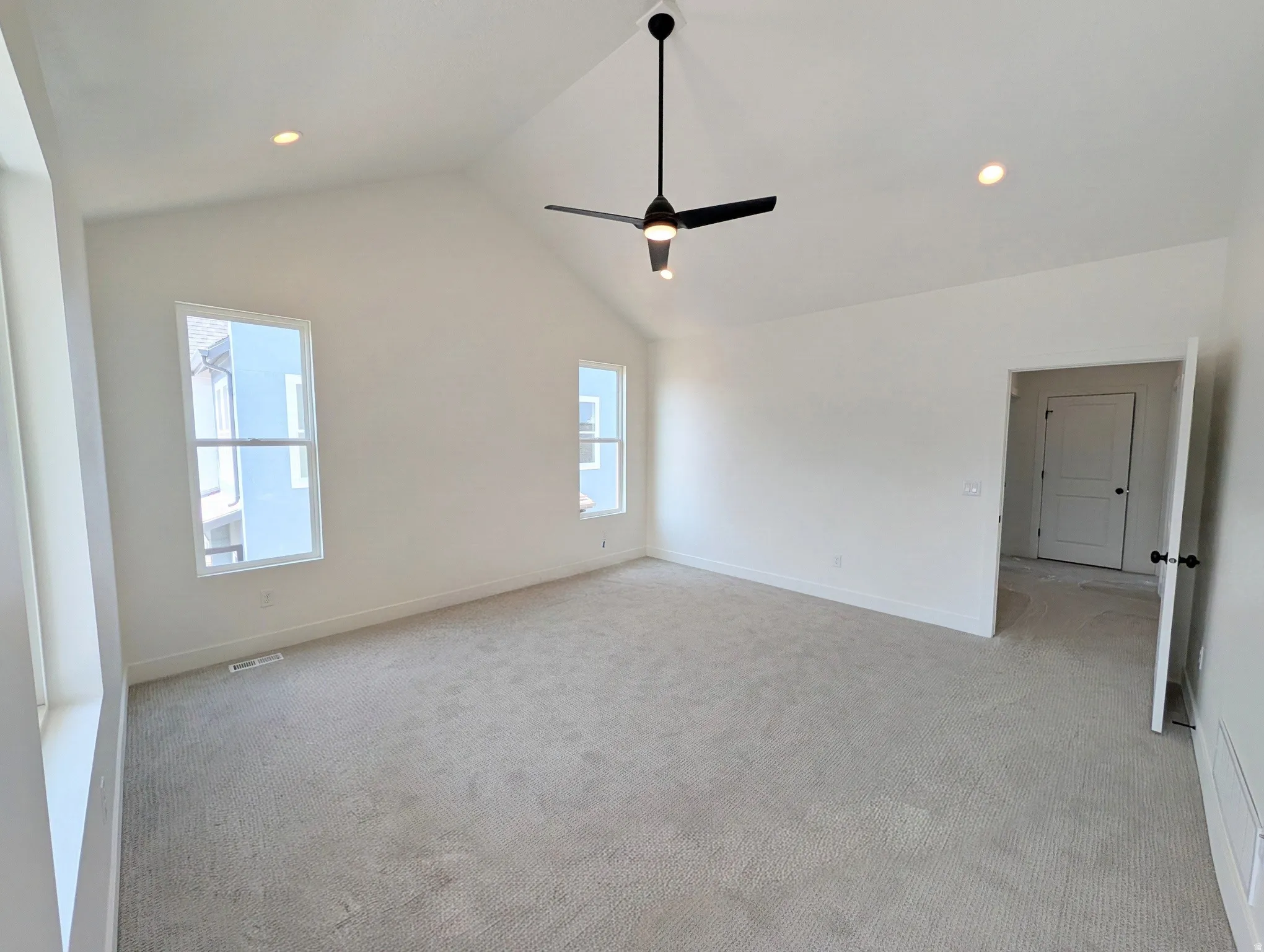 Primary bedroom with Vaulted ceiling with a black ceiling fan, recessed lighting, and carpet flooring