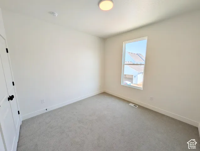 Neutral wall paint with white trim, gray carpet flooring, and a single window