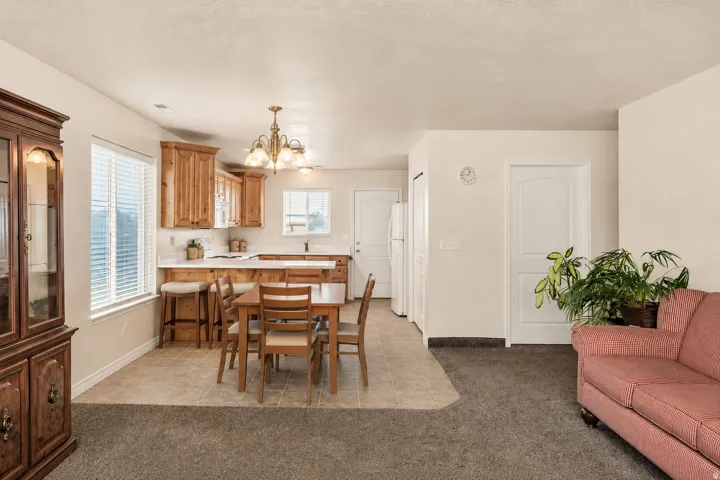 Kitchen featuring wood cabinetry, white countertops, and white subway tile backsplash with both area for a table and chairs and a breakfast bar.