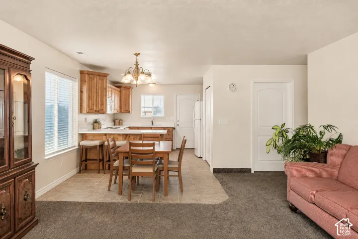 Kitchen featuring wood cabinetry, white countertops, and white subway tile backsplash with both area for a table and chairs and a breakfast bar.