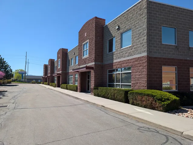 Multi-story building featuring a brick facade with a stone-finish upper level