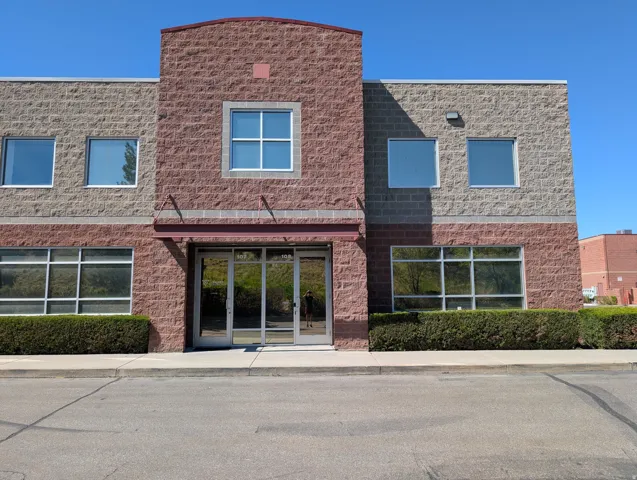 Two-story commercial building featuring a stone block exterior and multiple large windows