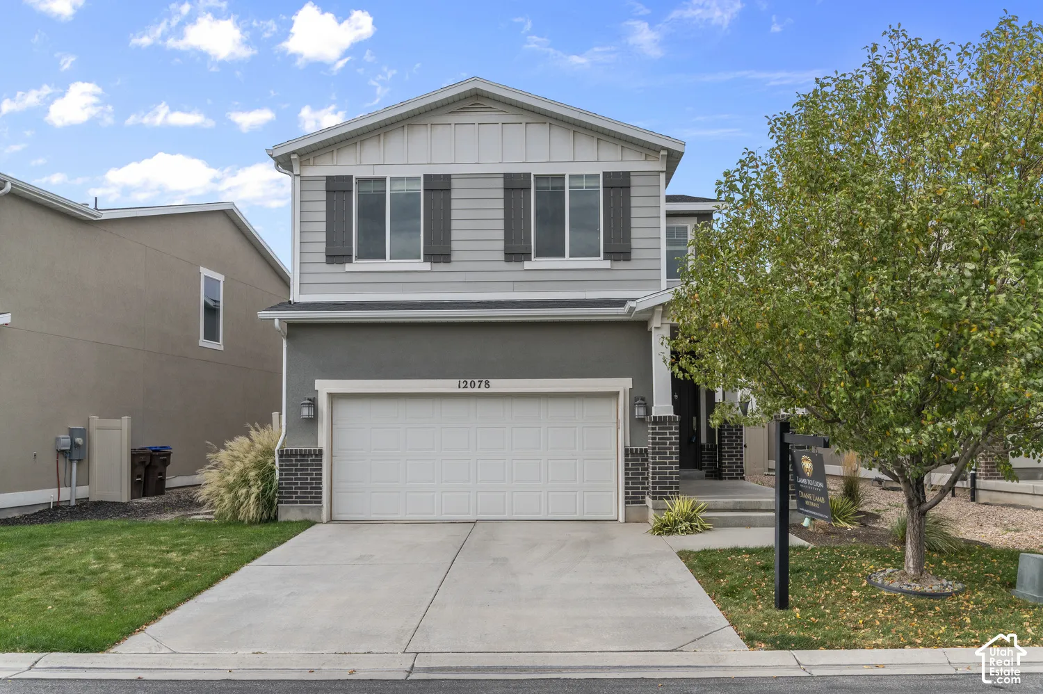 Two-story residence featuring a two-car garage, concrete driveway, and a manicured lawn